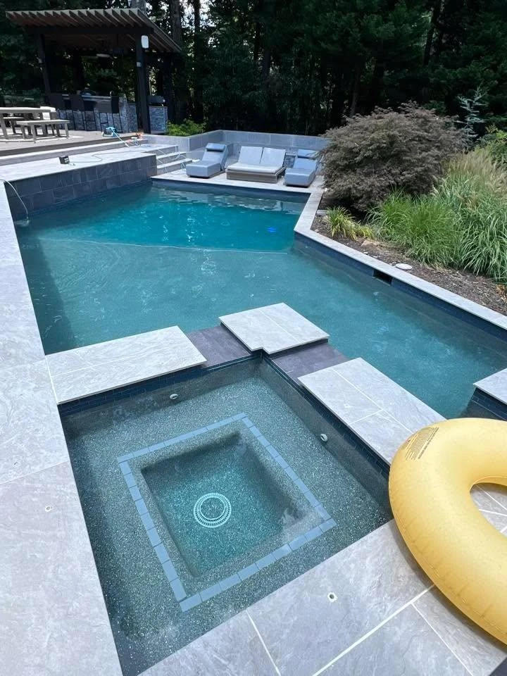 Rectangular pool with integrated spa and paver deck showing proper edge drainage in Alpharetta, GA