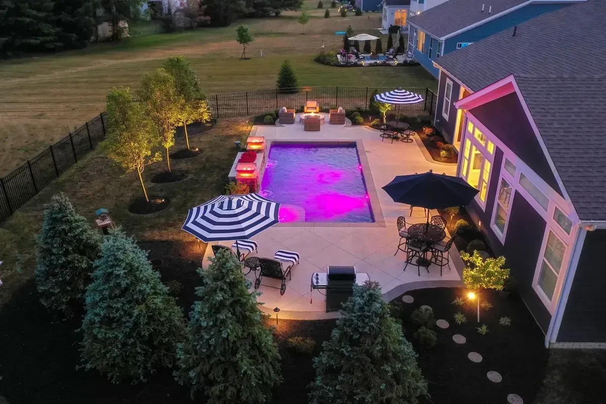 Pool and outdoor kitchen integrated patio area at dusk in Clarkston, GA