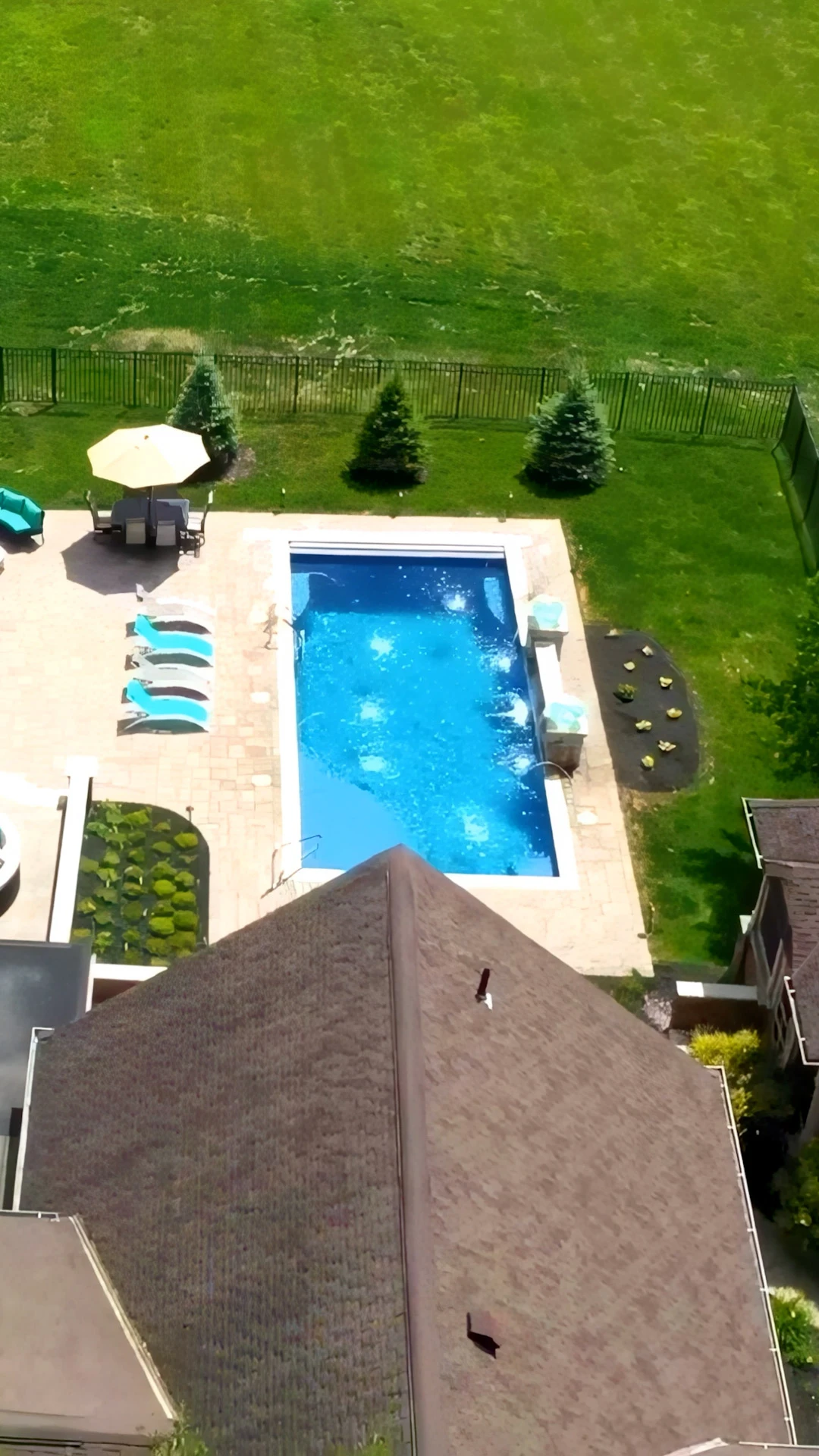Finished custom pool with travertine surround and landscaping in a Cumming, GA backyard
