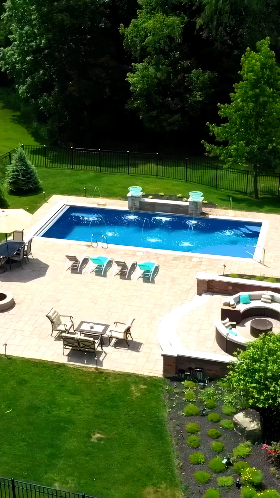 Aerial of rectangular pool with attached spa, deck jets, and paver deck coping in Forsyth County, GA