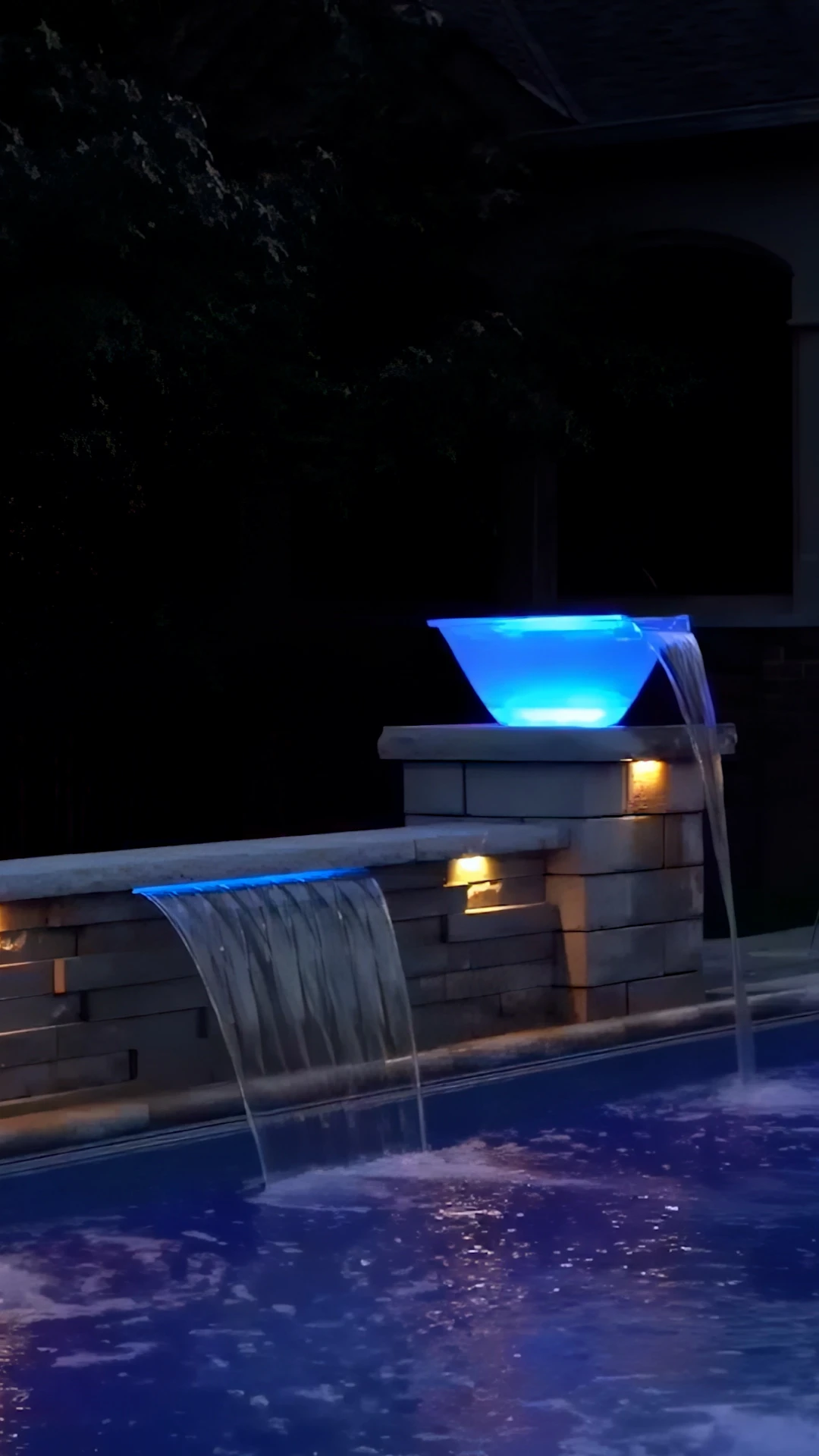 Illuminated blue LED square scupper on stacked-stone pier with sheet waterfall into a pool in Marietta, GA