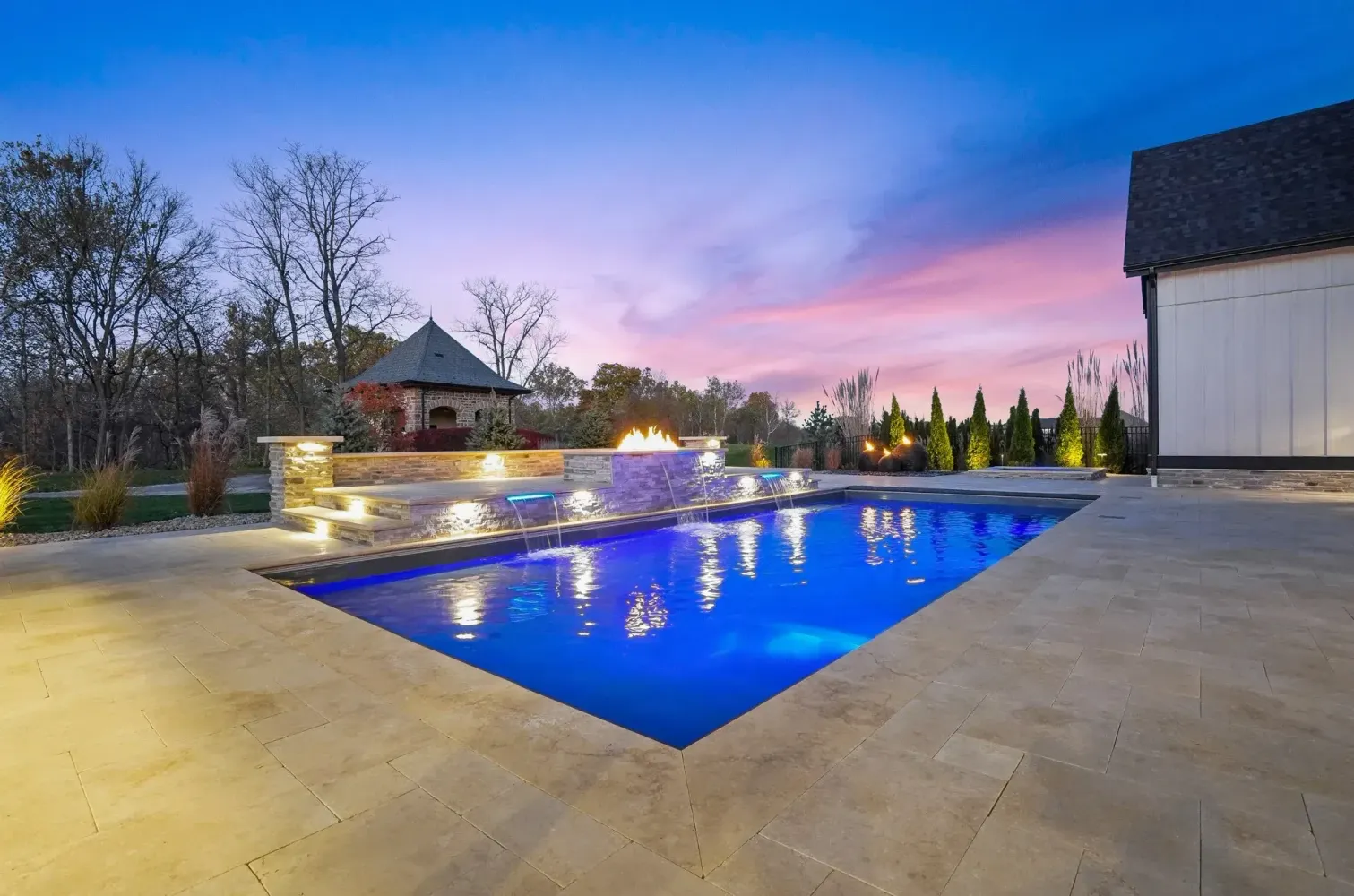 Evening view of custom pool deck with in-grade perimeter lighting and water-feature accents, Milton, GA