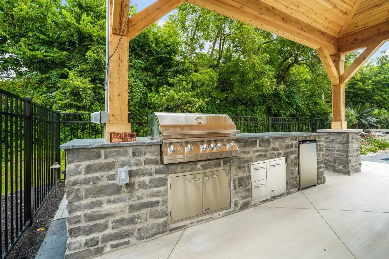 Stacked-stone outdoor kitchen with quartzite counter and built-in grill in Milton, GA