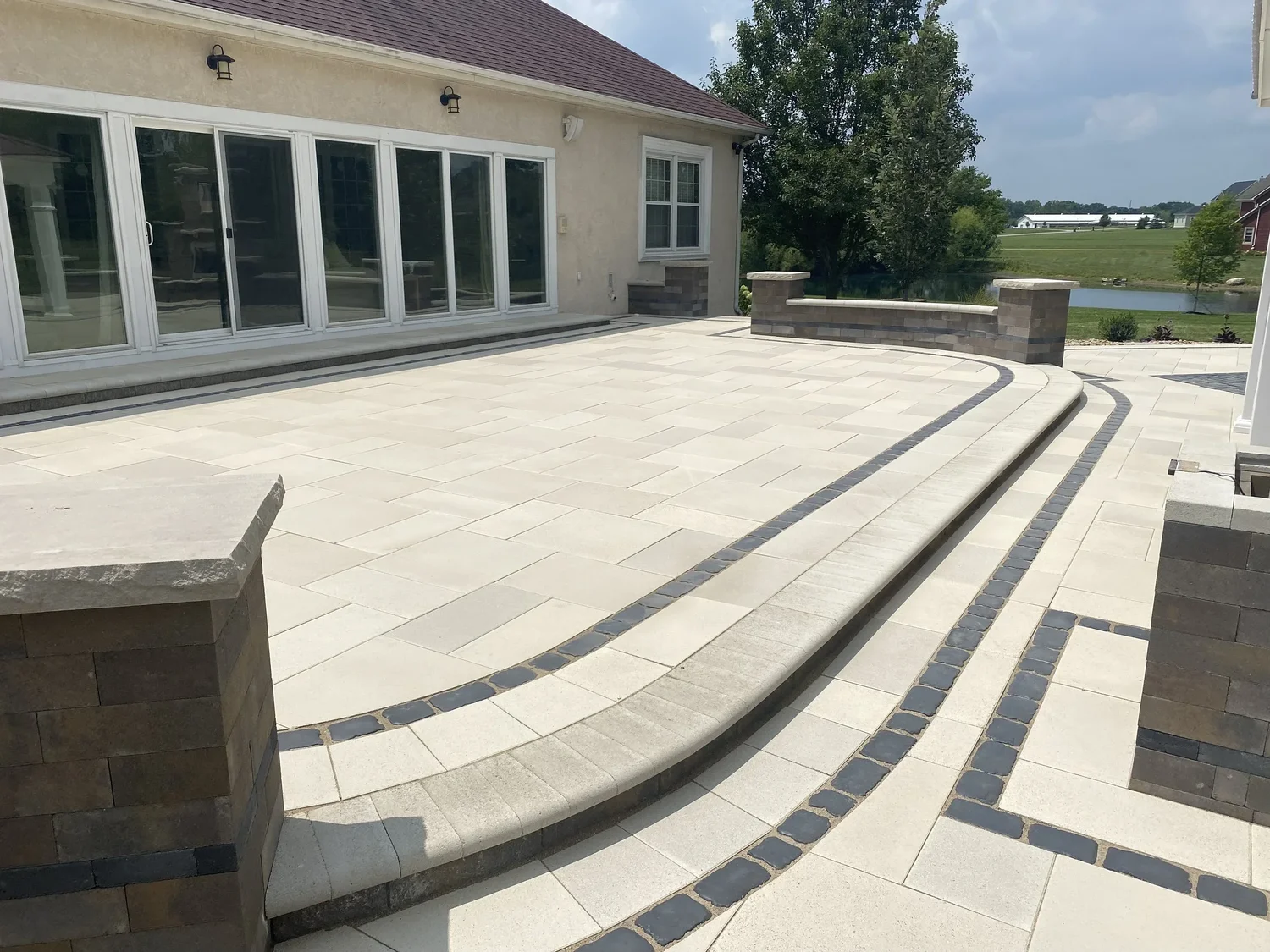 Large-format gray paver field set on screeded bedding sand with crew laying the running bond pattern, Cumming, GA
