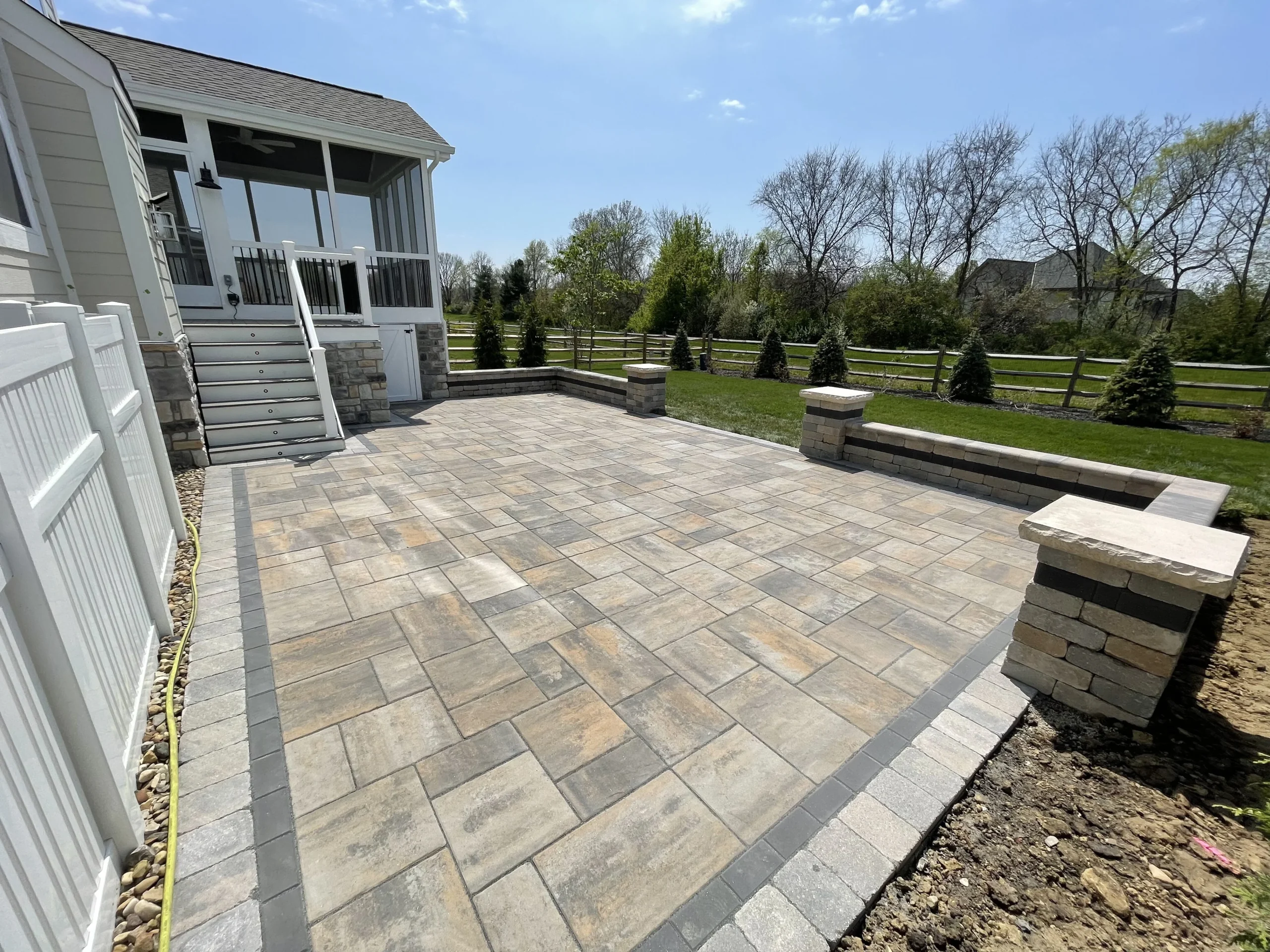 Finished paver patio with integrated firepit design details in Dacula backyard — Primetime Pools GA