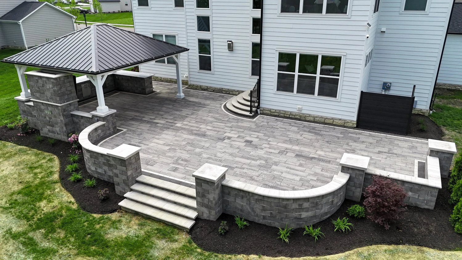 Paver patio install with curved edge detail on a sloped Dawsonville GA backyard near GA-400