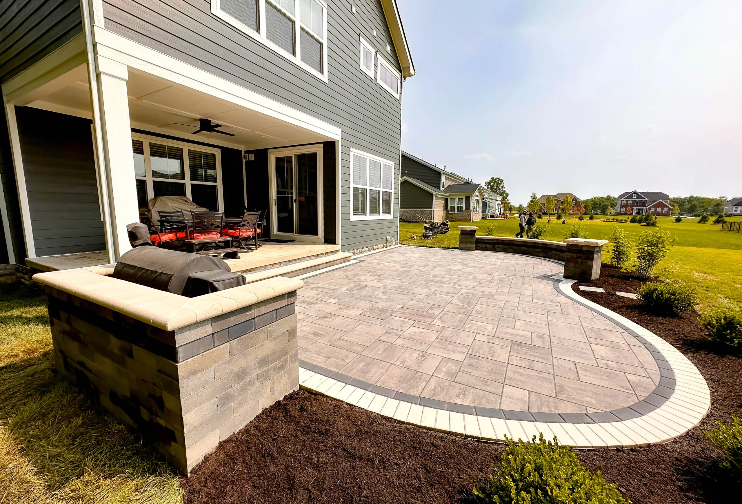 Paver patio with herringbone field pattern and contrasting border adjacent to a Marietta, GA lawn