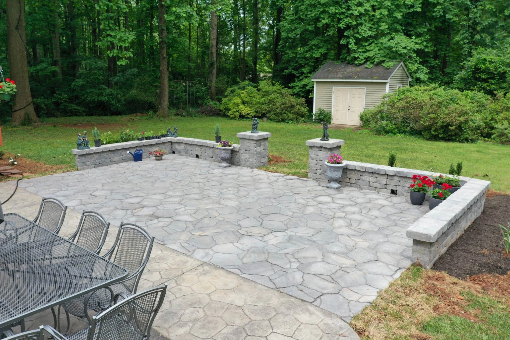 Flagstone-format large paver patio with tall seat wall and column planters in Suwanee, GA