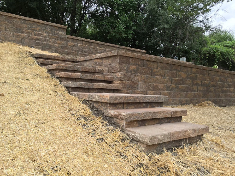 Tiered segmental block retaining wall holding a terraced backyard slope on a Cumming, GA subdivision lot