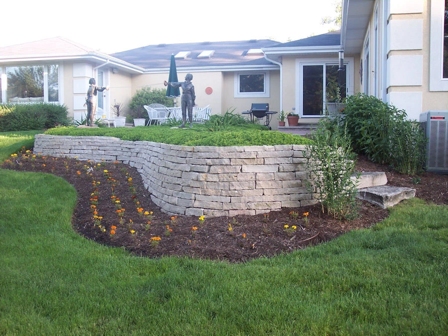 Finished tiered concrete block retaining wall with planter bed and perennial landscaping on a South Forsyth, GA hillside