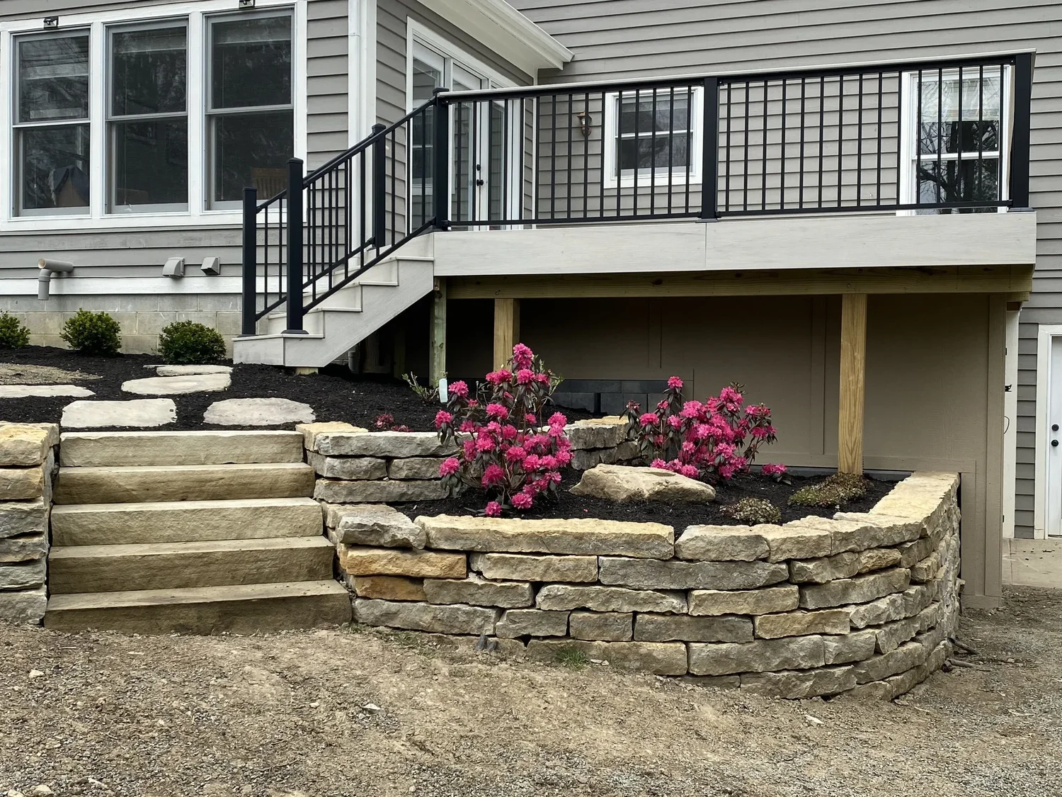 Natural-stone stair and flanking retaining walls leading from lawn to an elevated deck, walkout basement behind, Forsyth County, GA