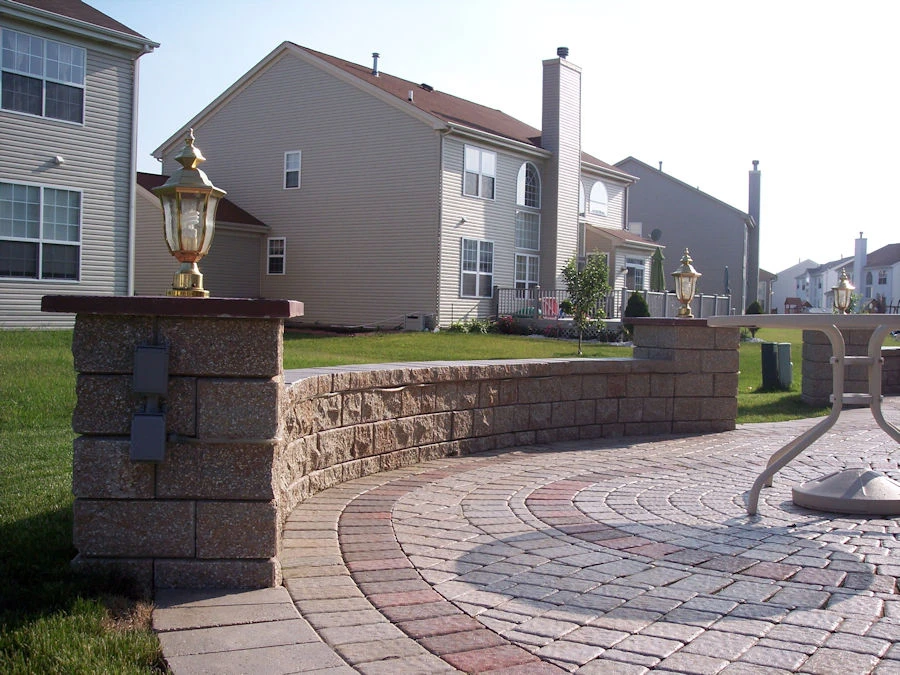 Engineered segmental retaining wall and patio grade transition on a sloped Suwanee lot