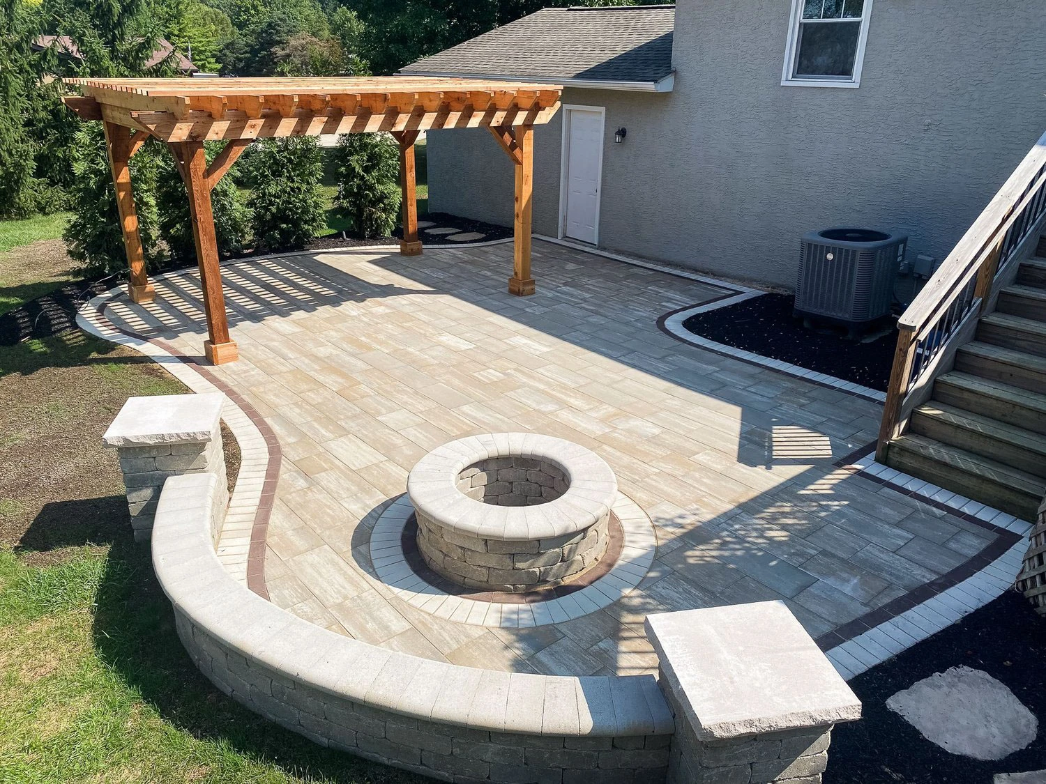 Backyard fire pit and pavilion with integrated landscape lighting on a Milton, GA estate