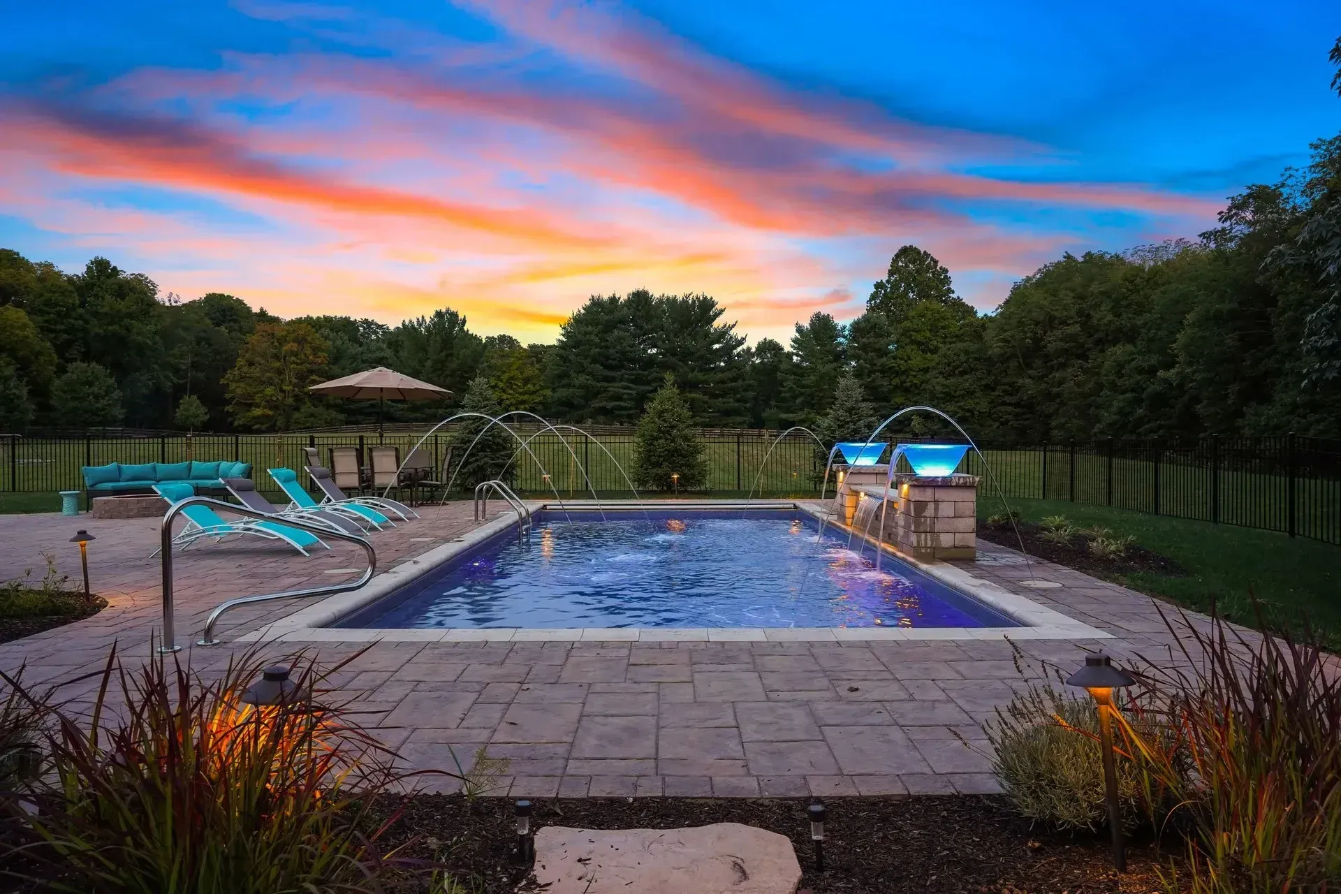 Tumbled ivory travertine pool deck in Clarkston GA with rectangular pool, coping, and surrounding hardscape on a summer afternoon