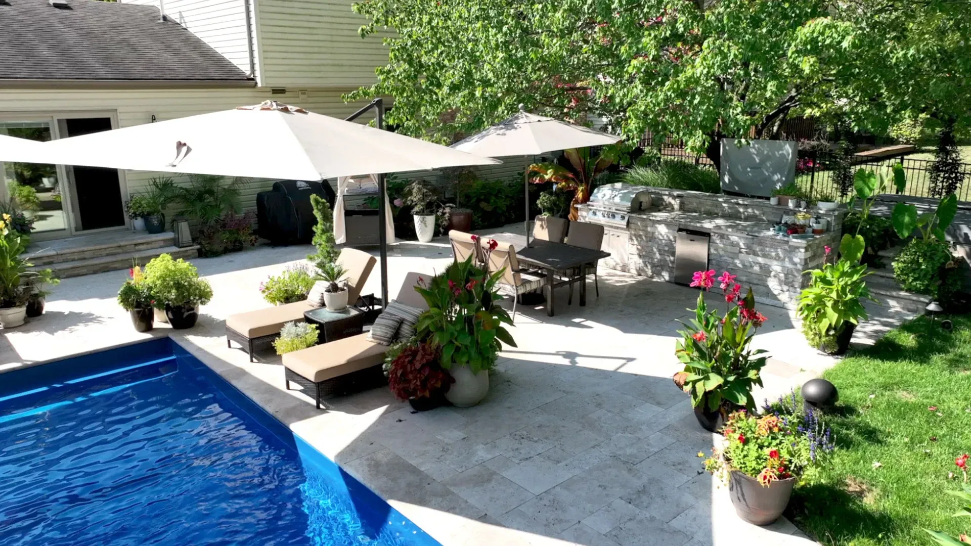 Travertine pool deck with square-profile coping on a shaded East Cobb backyard in Marietta, GA
