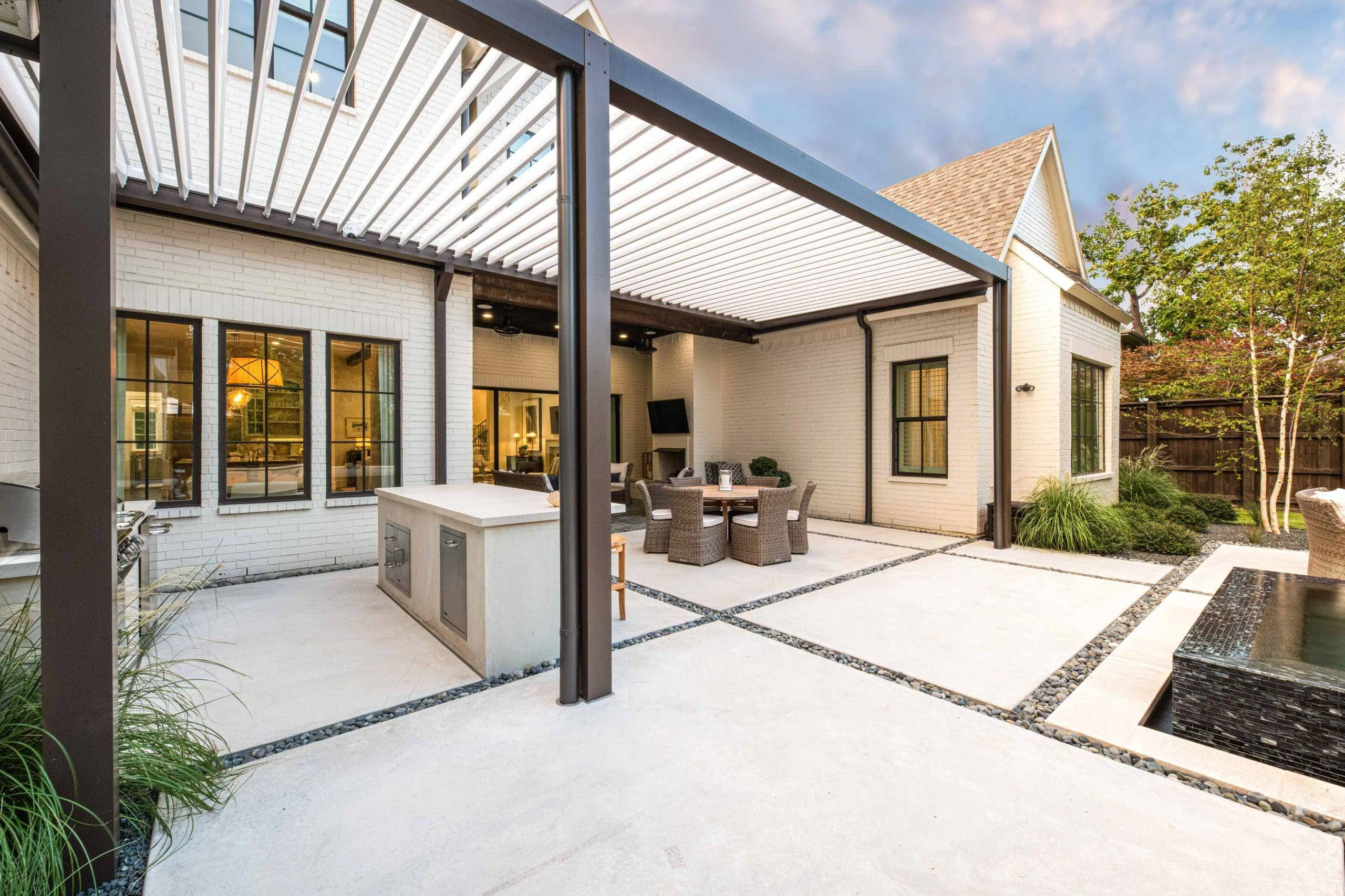 Attached pergola on a modern Marietta, GA home with the ledger tucked under a continuous flashing line above stone veneer