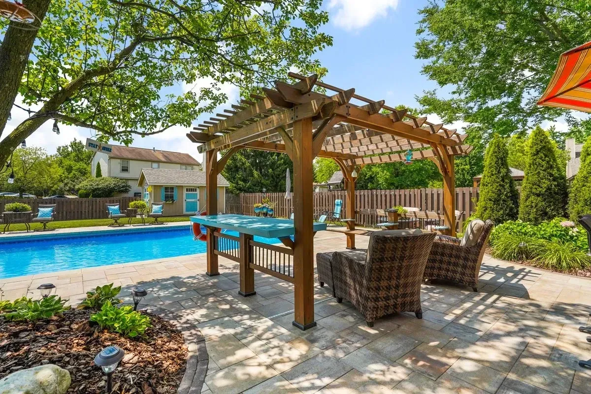 Pergola-covered outdoor kitchen and dining area in a Milton, GA backyard